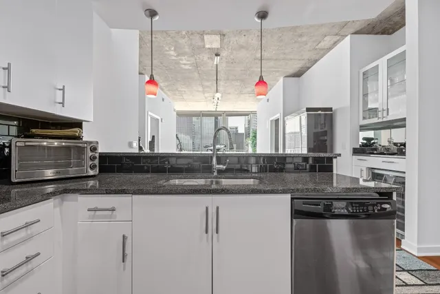 a kitchen with stainless steel appliances granite countertop a stove a sink and a microwave