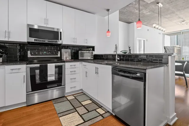 a kitchen with stainless steel appliances granite countertop a refrigerator a sink and a stove