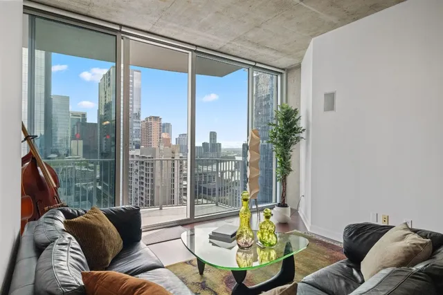 a living room with furniture and a floor to ceiling window