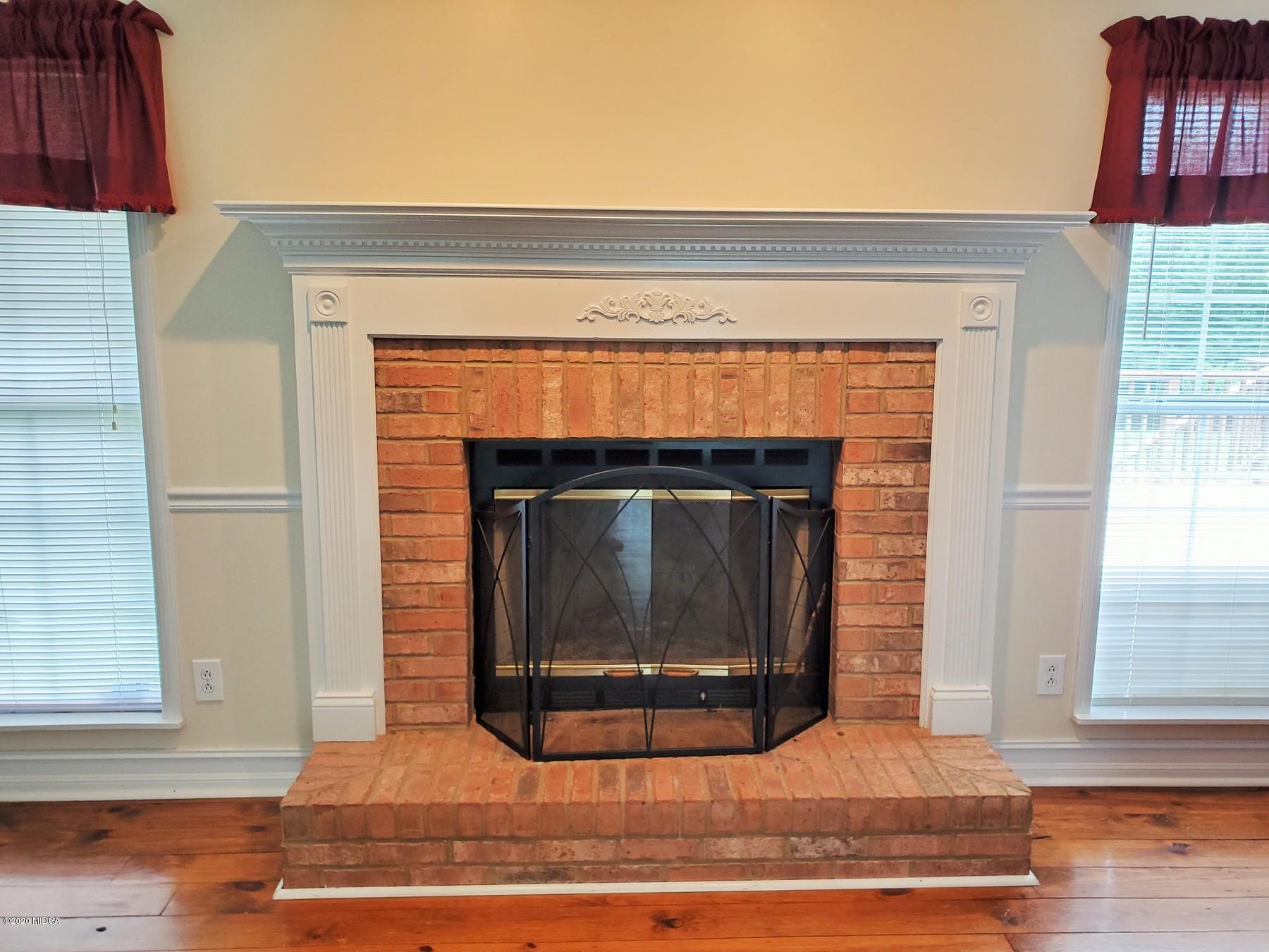 144 Gates Road Lizella, GA 31052 - Photo 22 of 44 a living room with a fireplace and a wooden floor