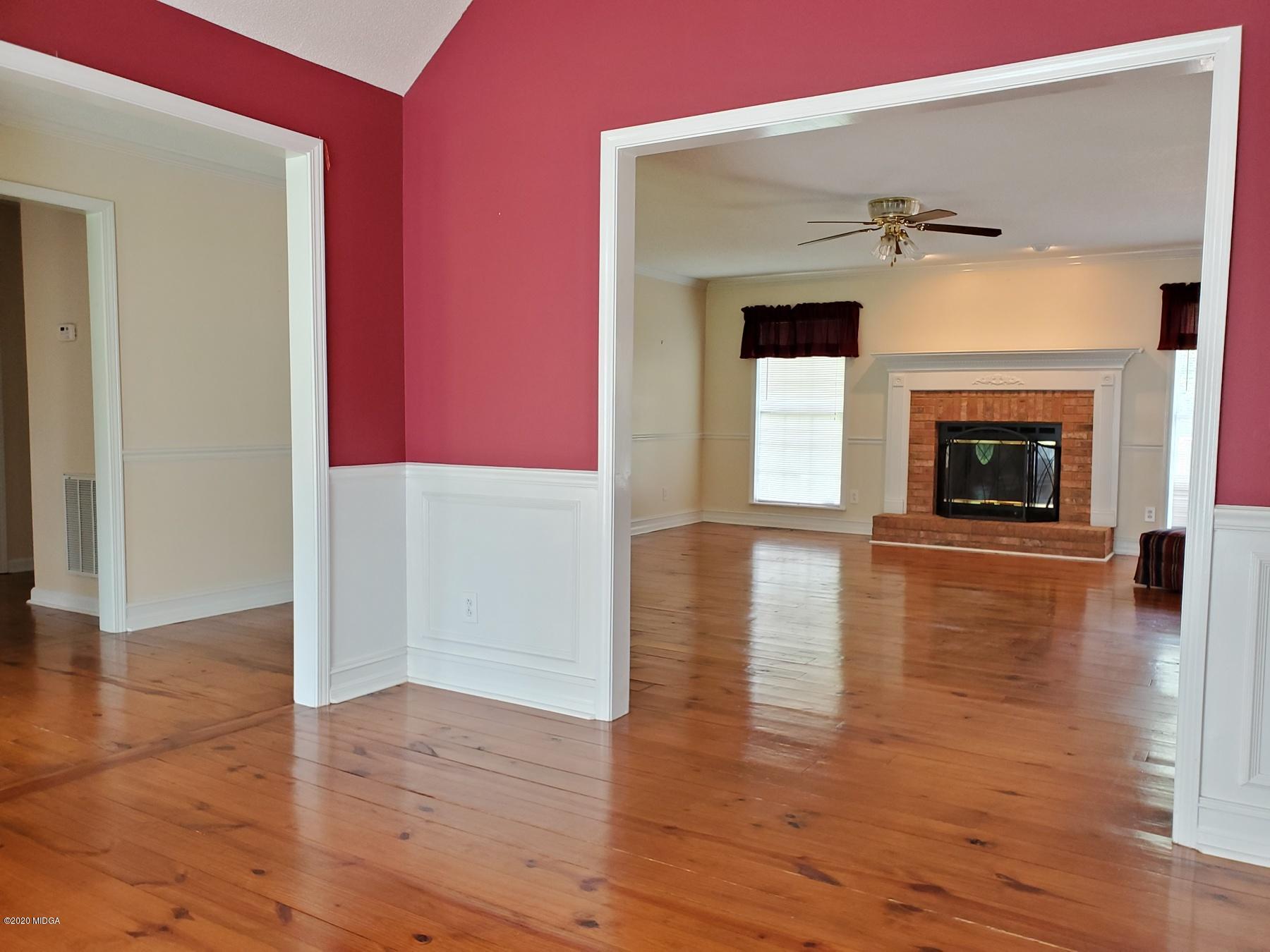144 Gates Road Lizella, GA 31052 - Photo 24 of 44 an empty room with wooden floor and fireplace