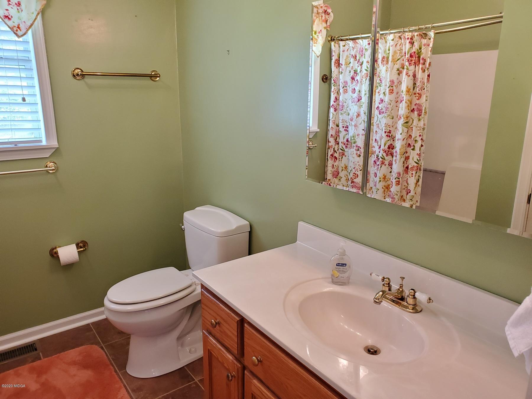 144 Gates Road Lizella, GA 31052 - Photo 35 of 44 a bathroom with a sink mirror vanity and toilet