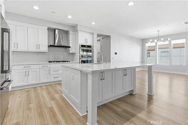 a kitchen with white cabinets appliances and a center island