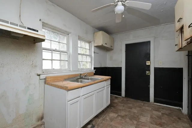 a utility room with granite countertop cabinets and washer