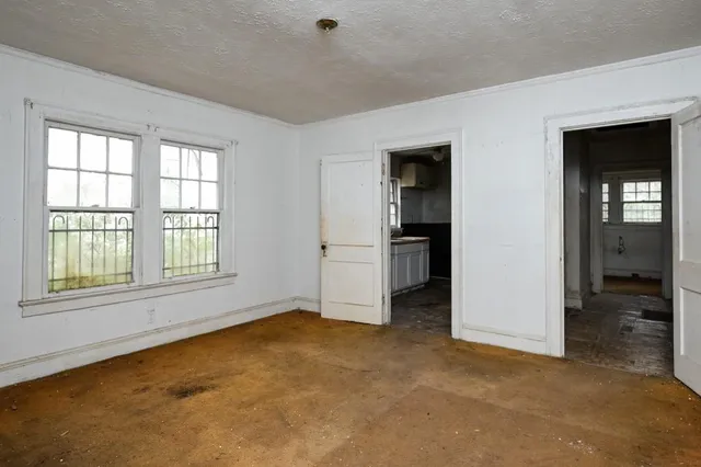 a view of an empty room with closet and a window