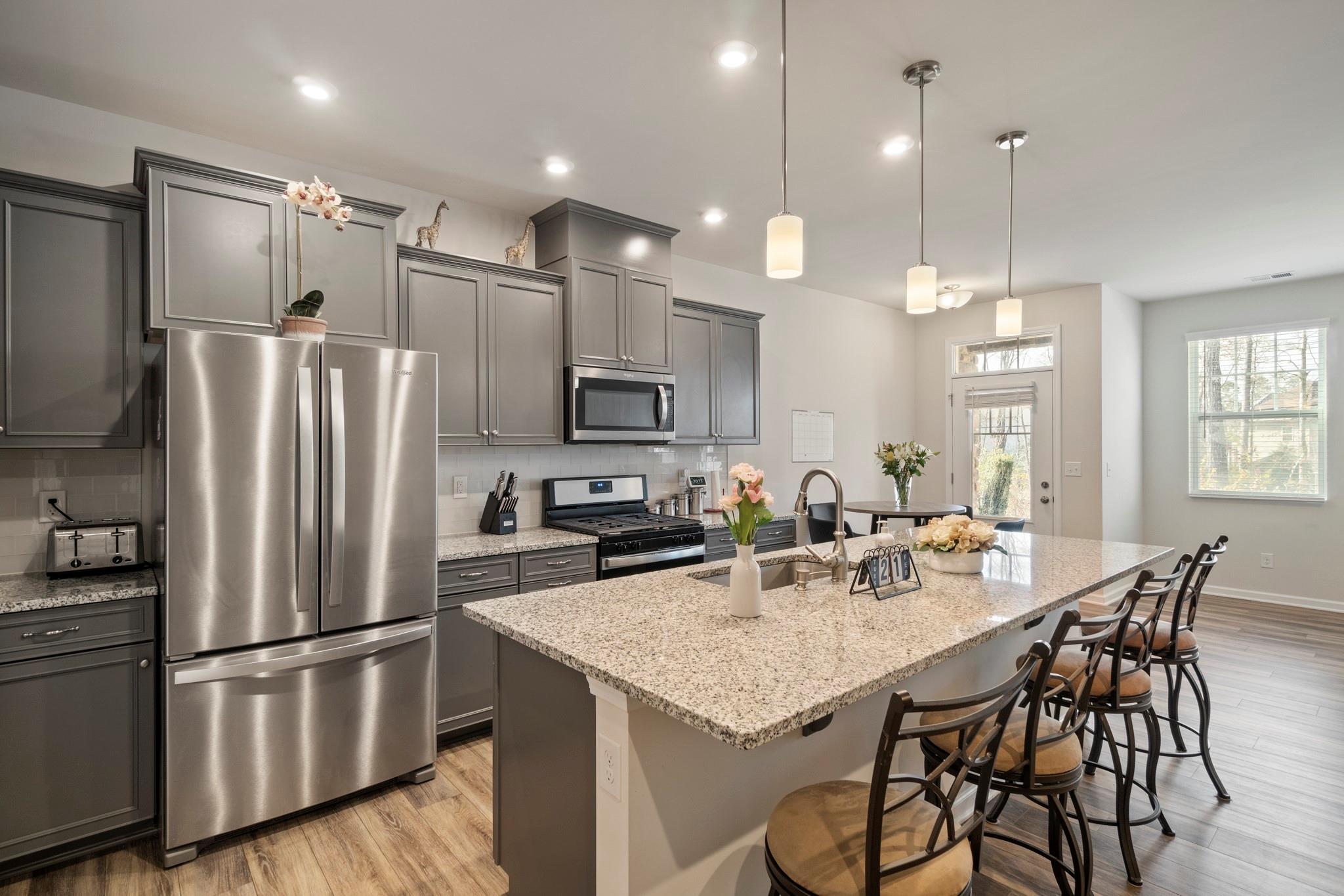 1564 Galloway Road Charlotte, NC 28262 - Photo 6 of 37 a kitchen with stainless steel appliances granite countertop a refrigerator a sink a stove a dining table and chairs