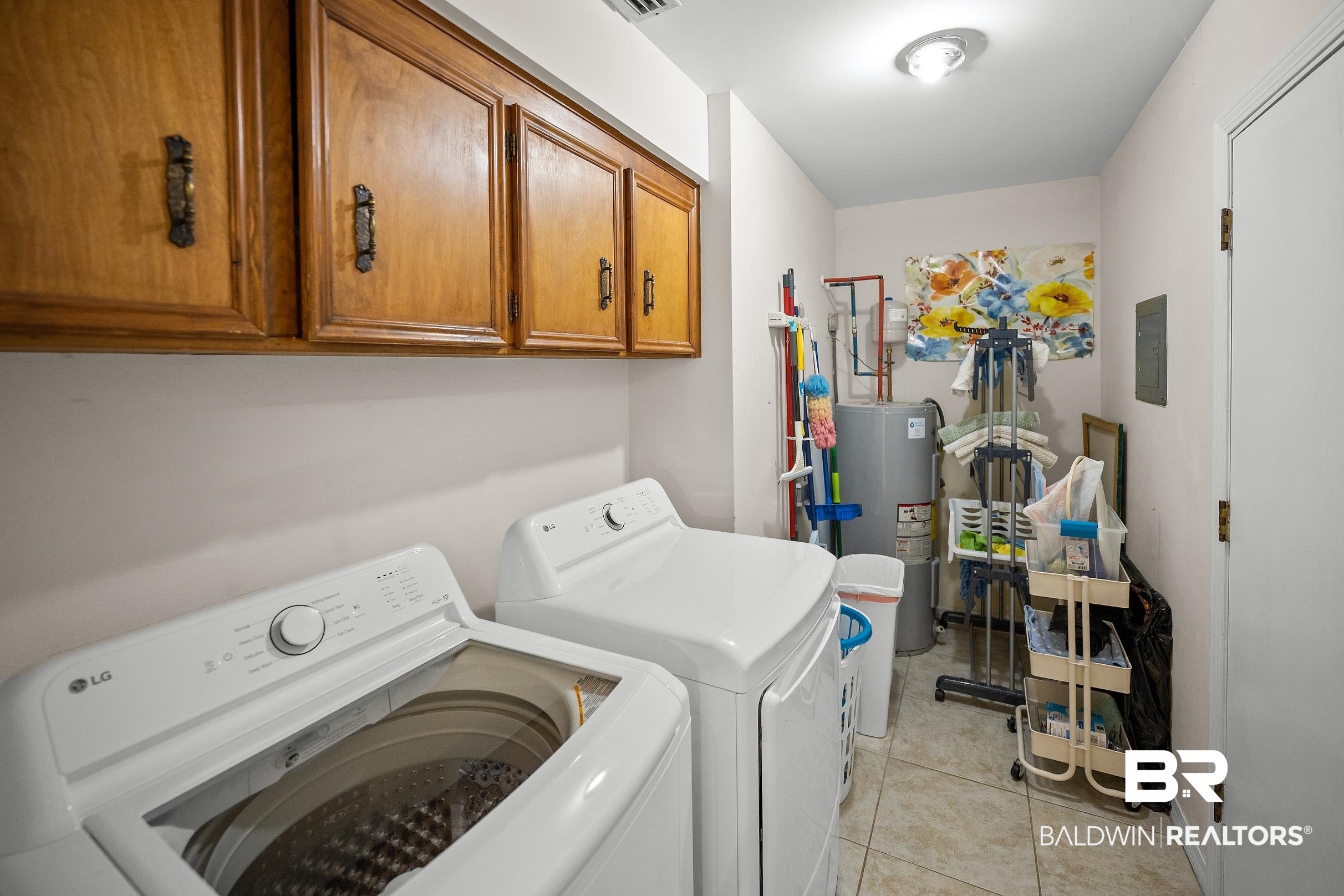 120 Dunbar Loop Daphne, AL 36526 - Photo 20 of 25 Laundry area featuring cabinet space, water heater, light tile patterned floors, washer and clothes dryer, and electric panel