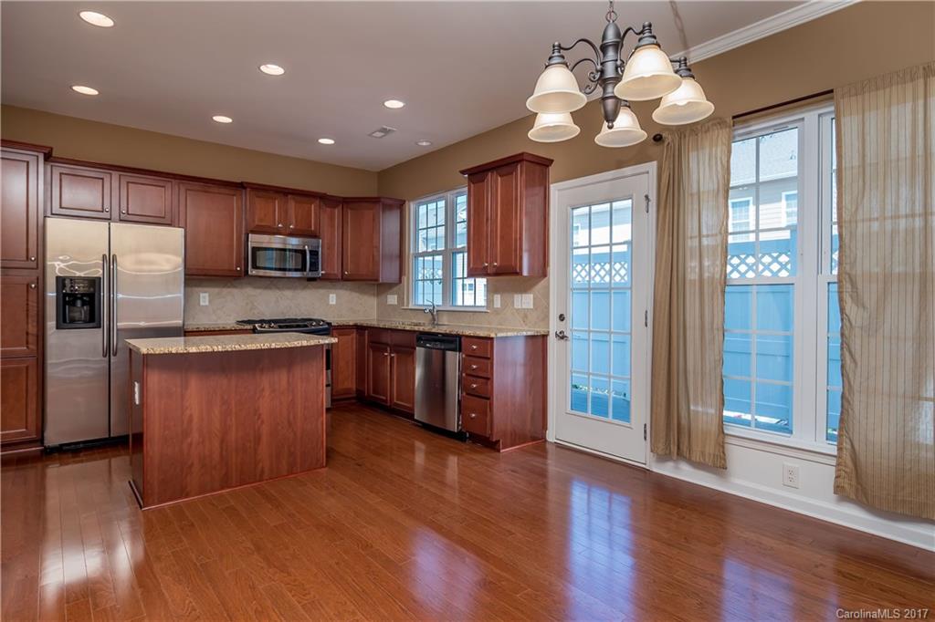 916 Lyndley Drive Fort Mill, SC 29708 - Photo 5 of 21 a kitchen with kitchen island granite countertop wooden floors stainless steel appliances a sink and a window