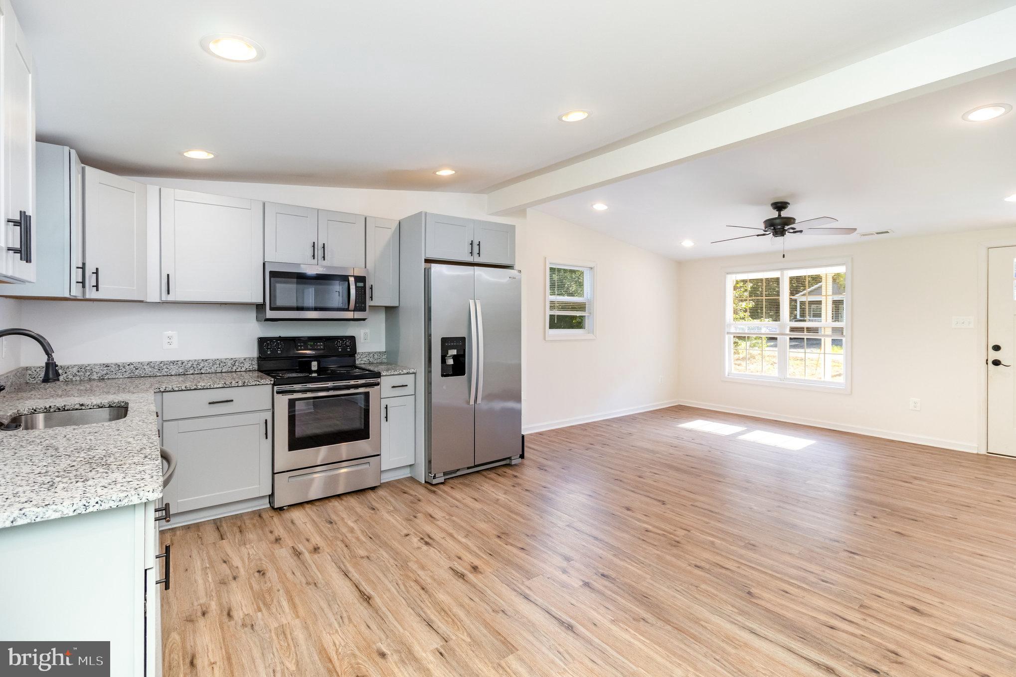 369 Circle Lane Colonial Beach, VA 22443 - Photo 2 of 18 a kitchen with stainless steel appliances granite countertop a refrigerator and a stove top oven