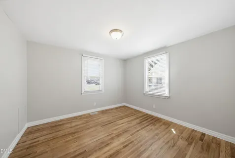 a view of a room with wooden floor and windows