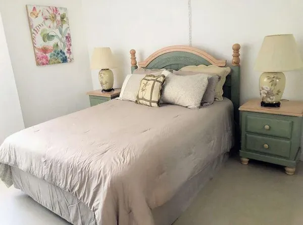 a bedroom with a bed and painting on the wall