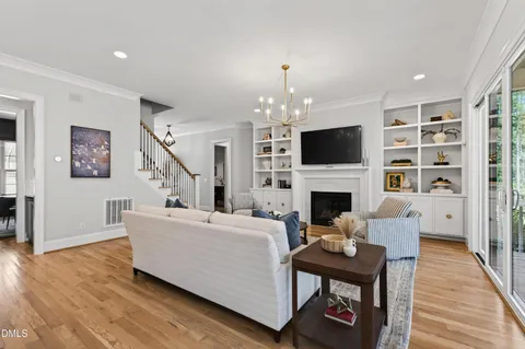 a kitchen with stainless steel appliances kitchen island granite countertop a stove a sink a refrigerator and white cabinets with wooden floor