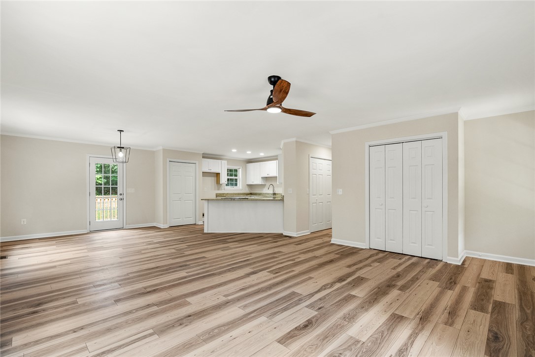 131 Lockaby Road Pelzer, SC 29669 - Photo 16 of 50 This bright, open-concept living space boasts wood flooring and a kitchen with an island.