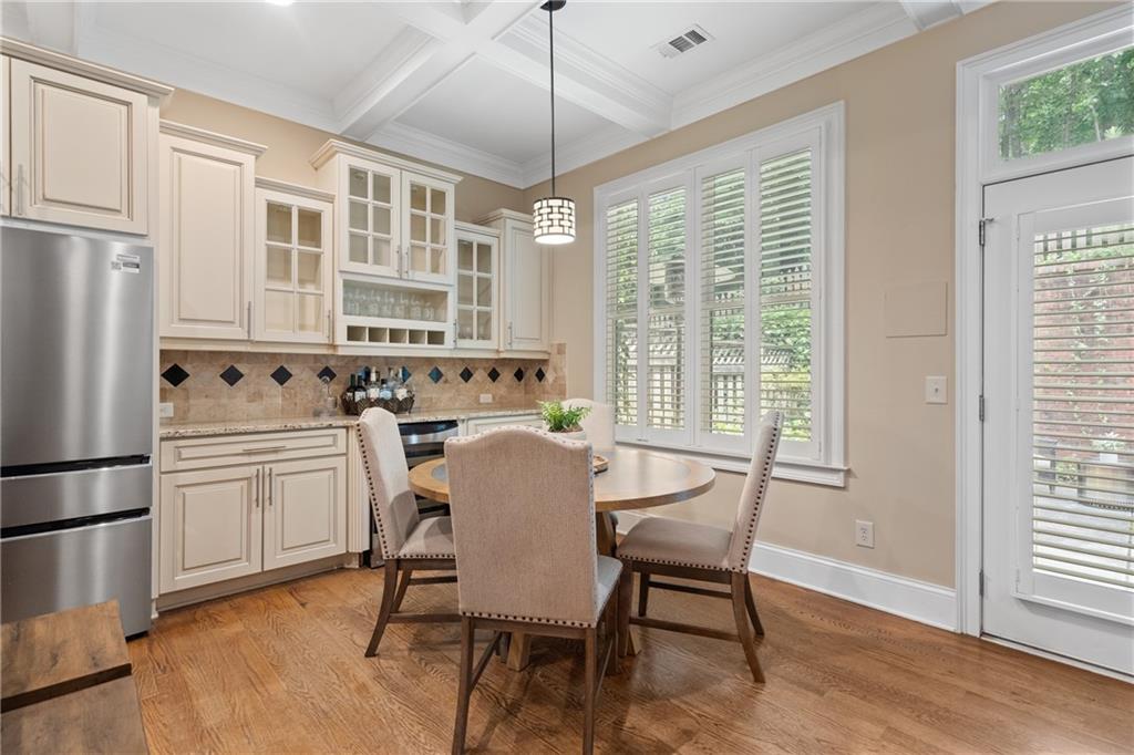 10567 Bent Tree View Duluth, GA 30097 - Photo 16 of 42 a kitchen with stainless steel appliances granite countertop a stove a refrigerator a dining table and chairs with wooden floor