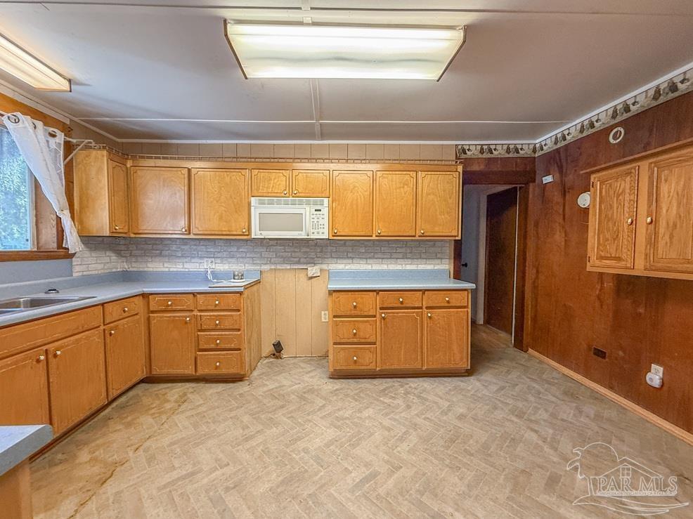 4550 Church Street Bagdad, FL 32583 - Photo 7 of 23 a kitchen with stainless steel appliances granite countertop a sink window and cabinets