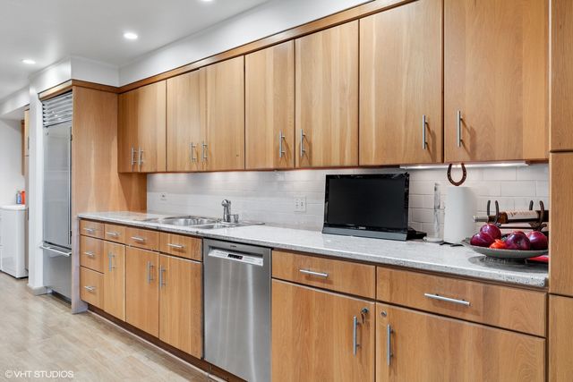 a kitchen with granite countertop a sink stainless steel appliances and cabinets