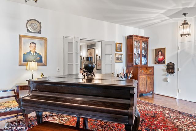 a living room with furniture a rug and a floor to ceiling window
