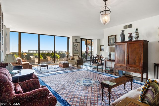 a living room with large windows and a table
