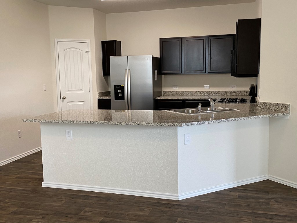 3607 Conyers Lane Austin, TX 78725 - Photo 3 of 24 a kitchen with stainless steel appliances granite countertop a refrigerator and a stove