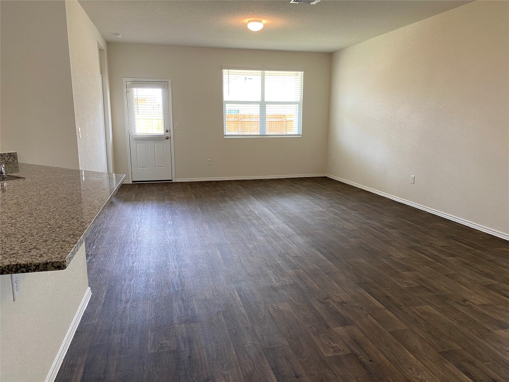 3607 Conyers Lane Austin, TX 78725 - Photo 6 of 24 an empty room with wooden floor and windows