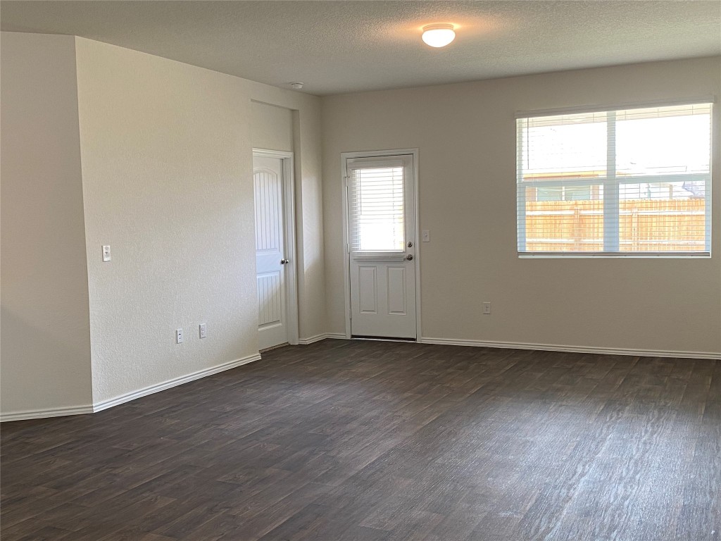 3607 Conyers Lane Austin, TX 78725 - Photo 9 of 24 an empty room with wooden floor and windows
