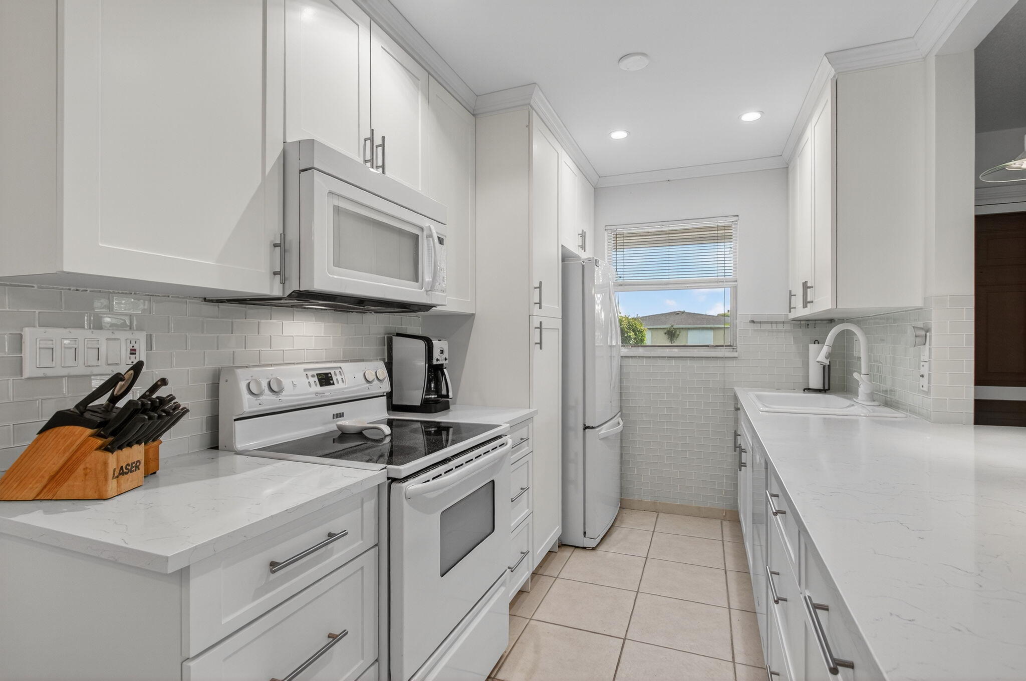 300 High Point Boulevard, Unit A Delray Beach, FL 33445 - Photo 14 of 37 a kitchen with cabinets and appliances