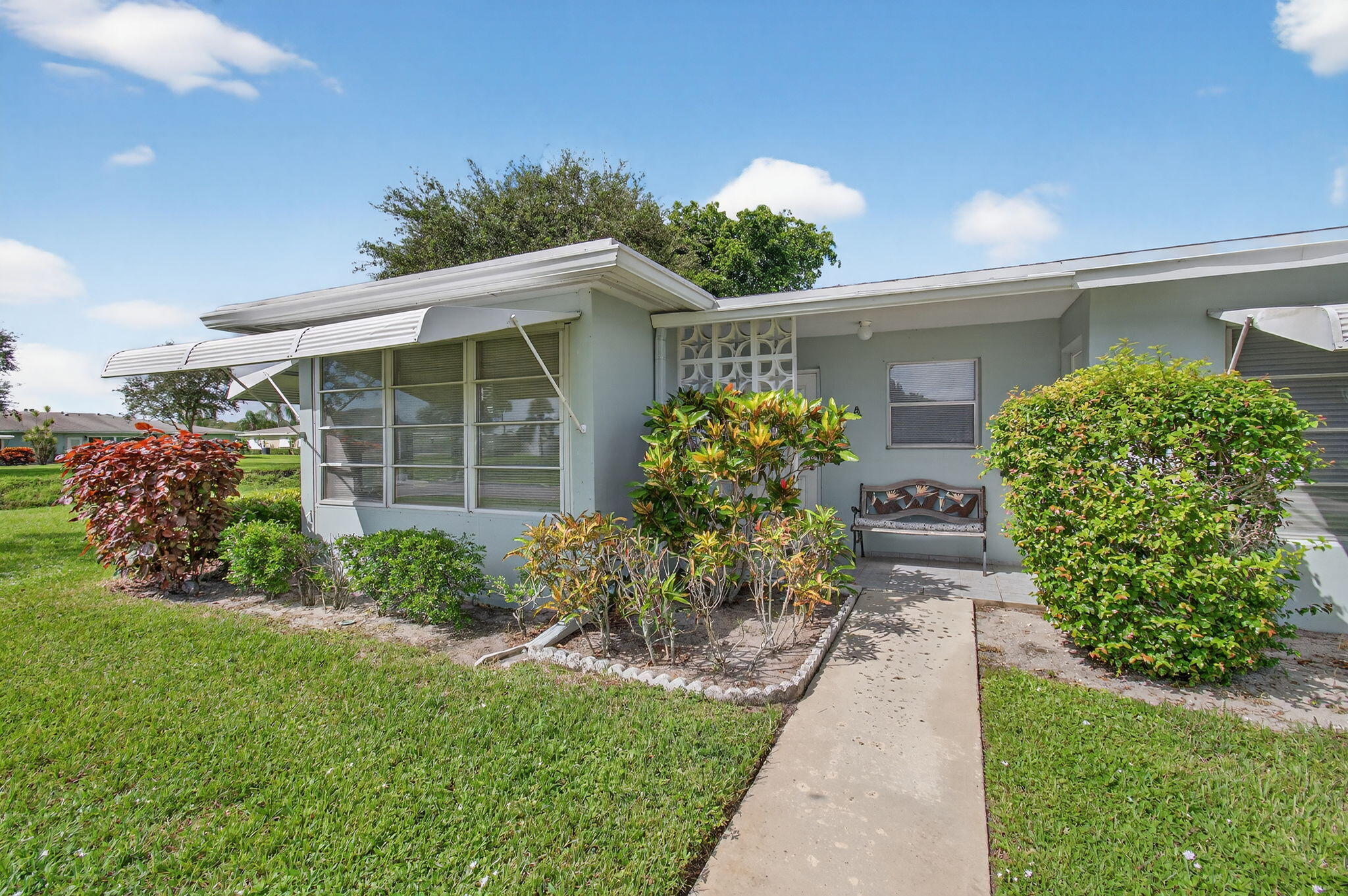 300 High Point Boulevard, Unit A Delray Beach, FL 33445 - Photo 3 of 37 a front view of a house with garden