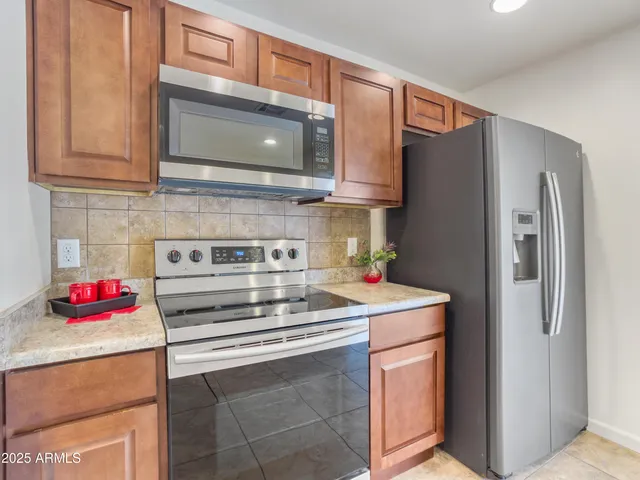a kitchen with stainless steel appliances granite countertop a refrigerator stove and sink
