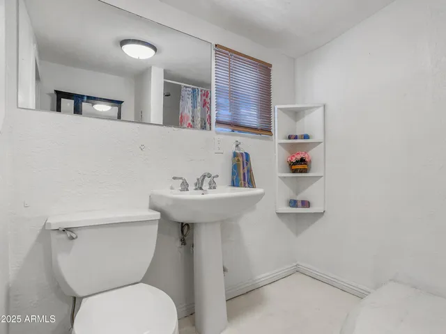 a bathroom with a sink toilet and mirror
