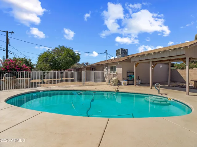 a view of a swimming pool with a patio and a yard