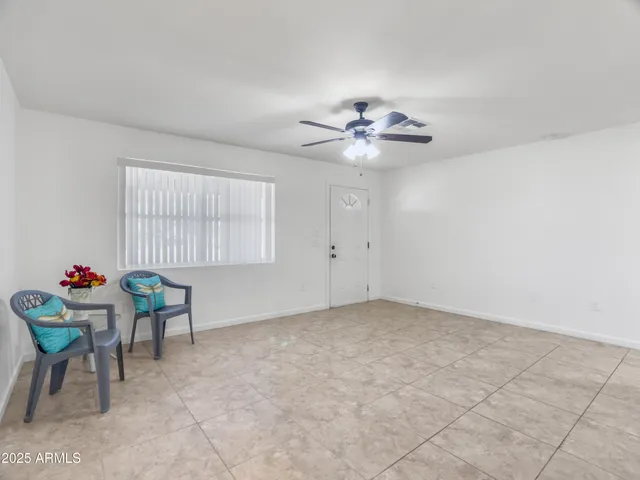 an empty room with fan and windows