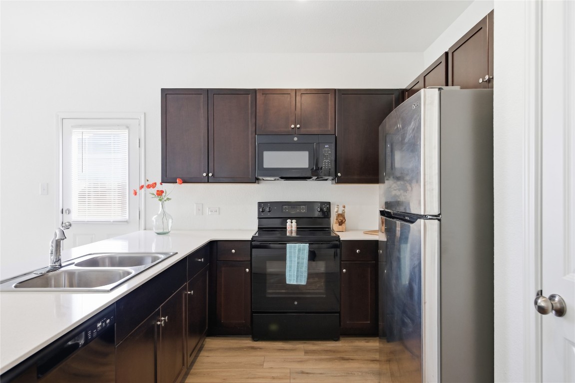 724 Rancho Del Cielo Loop Jarrell, TX 76537 - Photo 12 of 34 a kitchen with a refrigerator and a sink