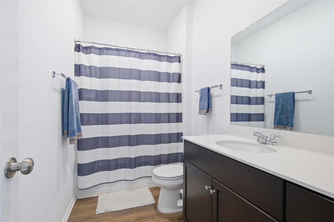 724 Rancho Del Cielo Loop Jarrell, TX 76537 - Photo 13 of 34 a bathroom with a sink a toilet a shower and a mirror