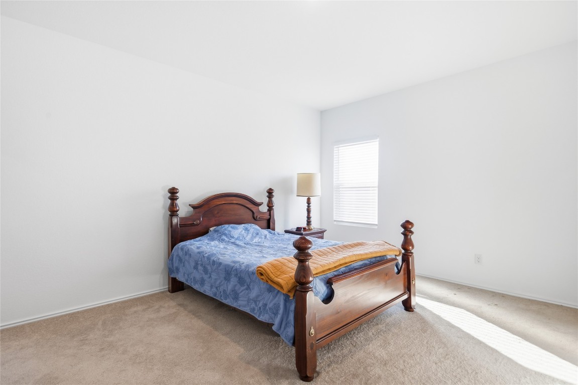 724 Rancho Del Cielo Loop Jarrell, TX 76537 - Photo 14 of 34 a bed sitting in a bedroom next to a window