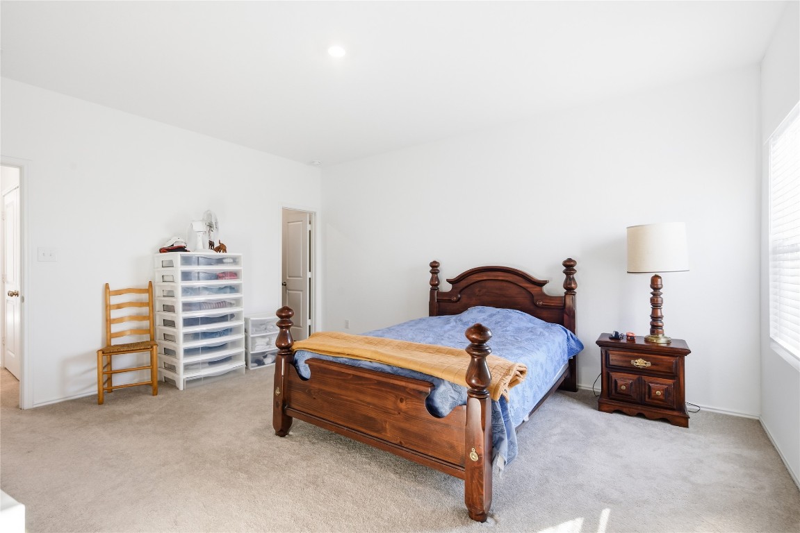 724 Rancho Del Cielo Loop Jarrell, TX 76537 - Photo 15 of 34 a bedroom with a bed and a lamp