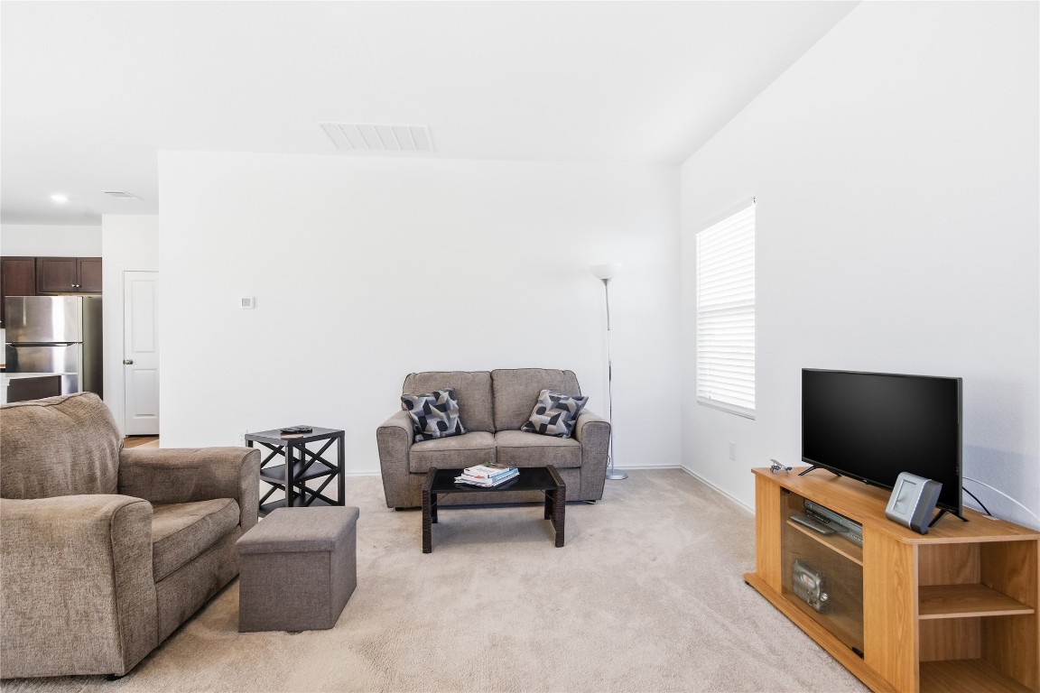 724 Rancho Del Cielo Loop Jarrell, TX 76537 - Photo 3 of 34 a living room with furniture and a flat screen tv