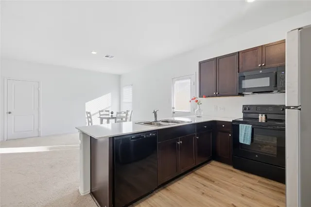 a kitchen with a sink a stove and cabinets