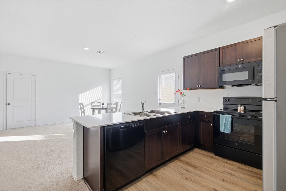 724 Rancho Del Cielo Loop Jarrell, TX 76537 - Photo 4 of 34 a kitchen with a sink a stove and cabinets