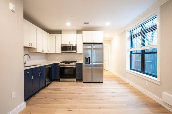 a kitchen with stainless steel appliances granite countertop a refrigerator stove top oven and sink