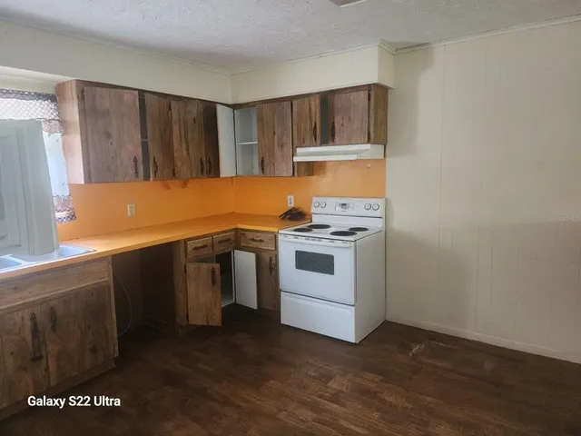 a kitchen with white cabinets and a stove top oven