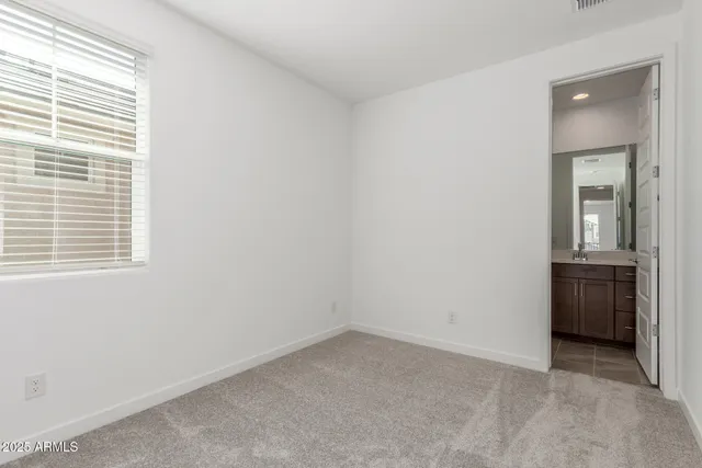 an empty room with a window and a kitchen
