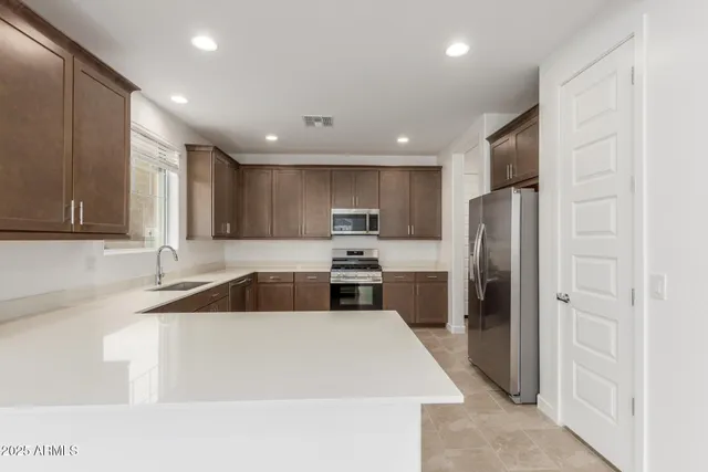 a kitchen with stainless steel appliances granite countertop a refrigerator and a sink