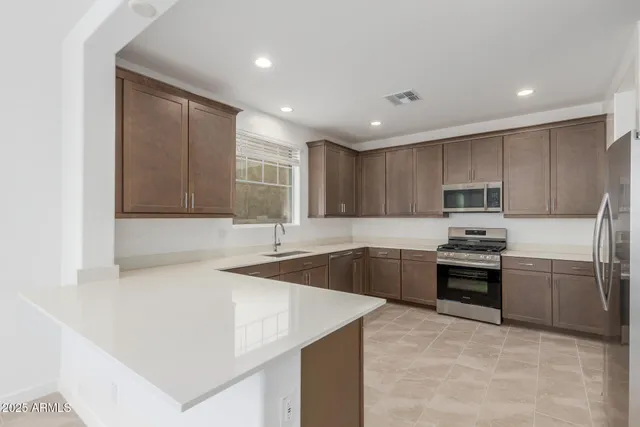 a kitchen with stainless steel appliances granite countertop a sink stove and refrigerator