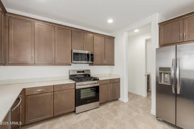 a kitchen with stainless steel appliances granite countertop a refrigerator stove and sink