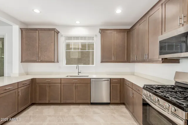 a kitchen with stainless steel appliances a sink stove and cabinets