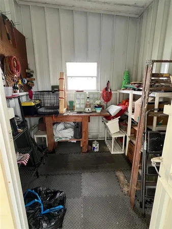 a work room with furniture a air conditioner vent and a window