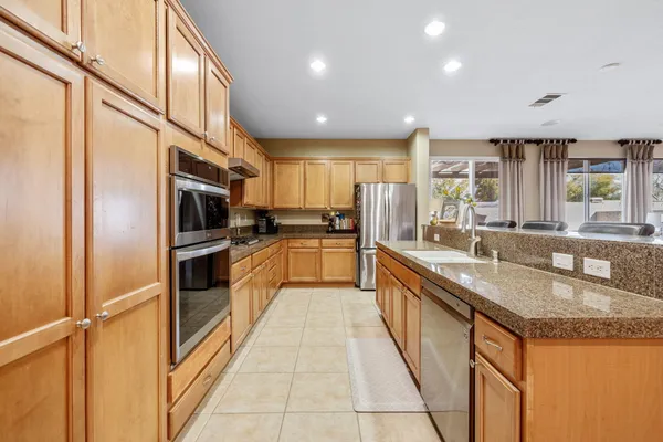 a kitchen with stainless steel appliances granite countertop a sink a stove and a refrigerator