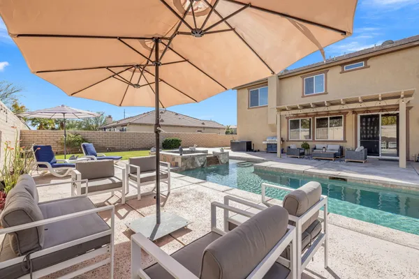 a view of a patio with a table and chairs under an umbrella