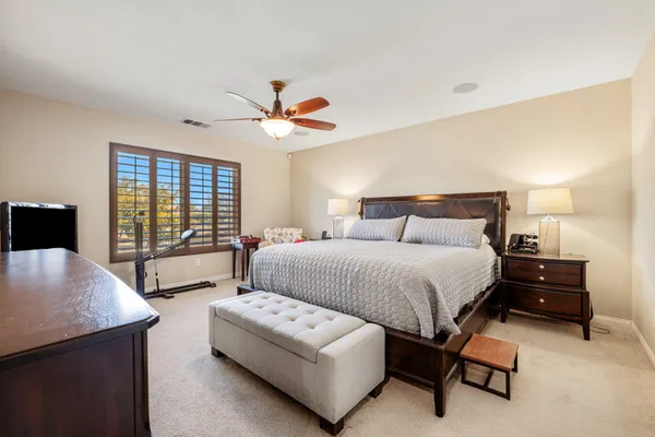 a bedroom with a large bed and a chandelier