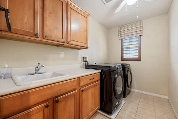 a utility room with granite countertop cabinets washer and dryer